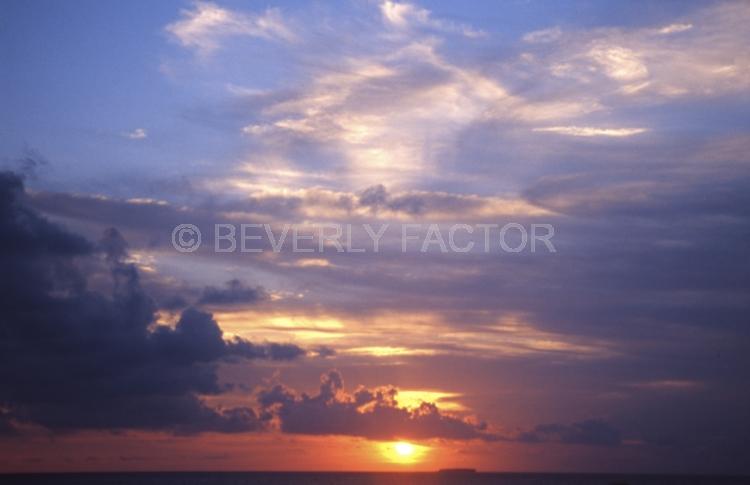 Islands;sunsets;sky;clouds;colorful;blue water;sun;yellow;red;pink;sillouettes;blue;maldive island